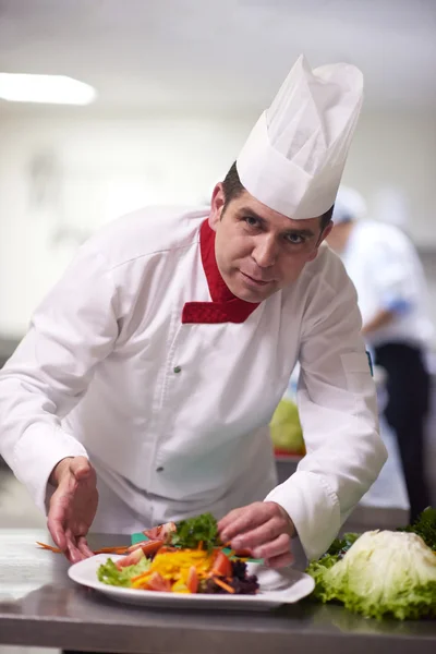 Chef en cocina preparando y decorando alimentos —  Fotos de Stock