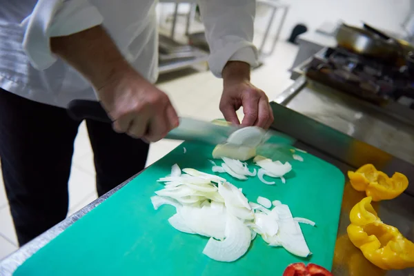 Chef na cozinha cortando legumes com faca — Fotografia de Stock