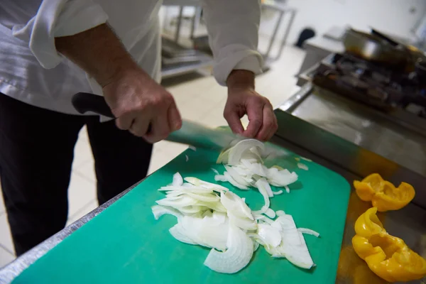 Chef na cozinha cortando legumes com faca — Fotografia de Stock