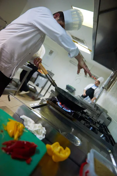 Chefs en cocina preparando comida con fuego —  Fotos de Stock