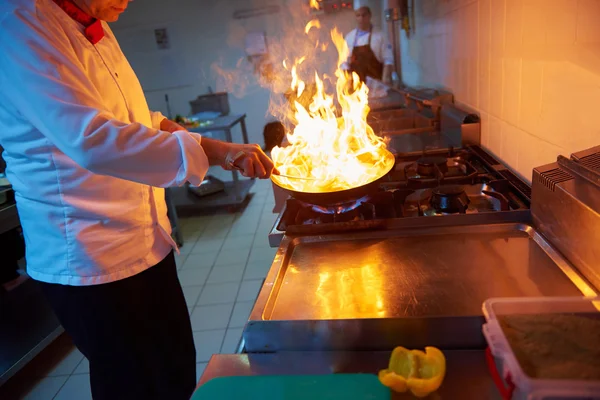 厨师在厨房里准备用火的食物 — 图库照片