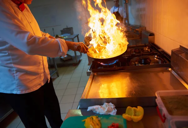 Chef in kitchen prepare food with fire — Stock Photo, Image