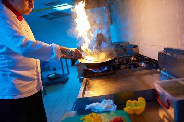 Chef na cozinha preparar comida com fogo — Fotografia de Stock