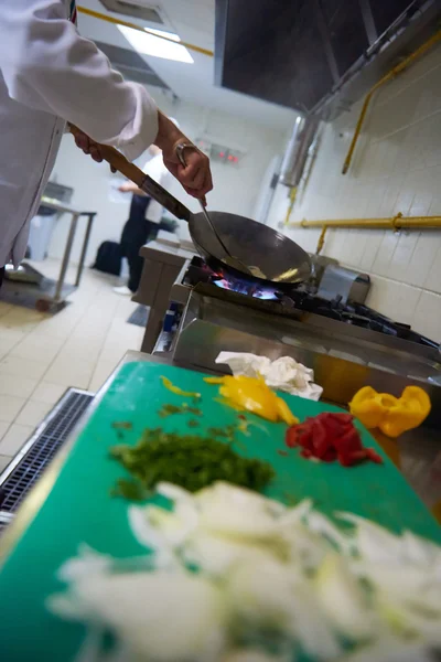 Koch in Küche bereitet Essen mit Feuer zu — Stockfoto