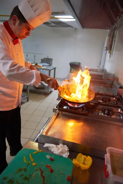 Chef en la cocina preparar la comida con fuego —  Fotos de Stock