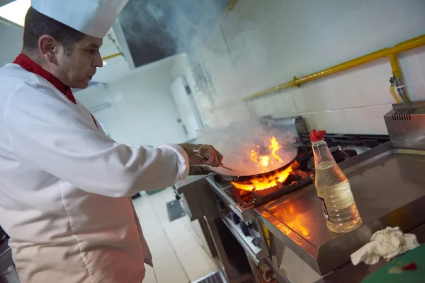 Chef in kitchen prepare food with fire — Stock Photo, Image