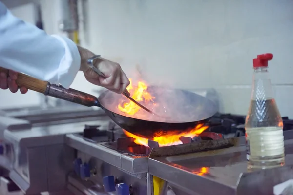 Chef na cozinha preparar comida com fogo — Fotografia de Stock