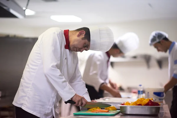 Chef in hotel kitchen slicing vegetables — Stock Photo, Image