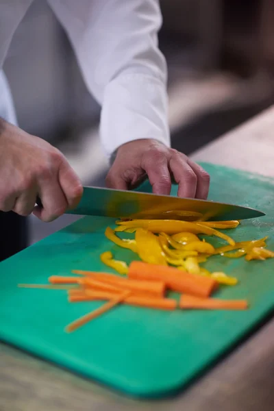 Chef dans la cuisine de l'hôtel tranchant des légumes avec couteau — Photo