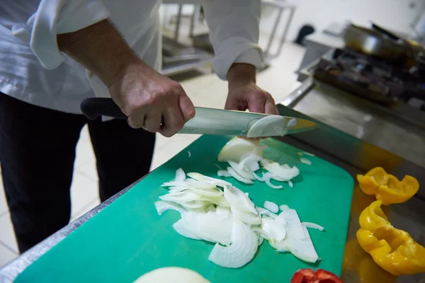 Chef-kok in de keuken van hotel snijden van groenten met mes — Stockfoto