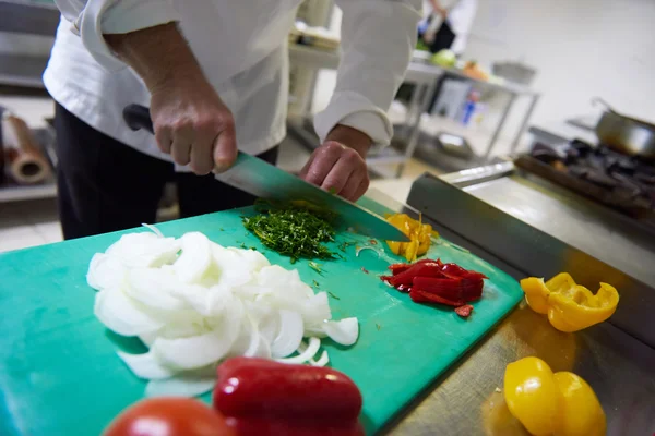 Chef-kok in de keuken van hotel snijden van groenten met mes — Stockfoto