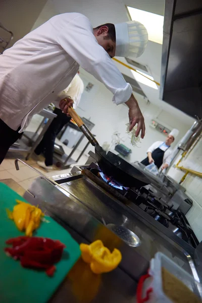 Шеф-повар готовит овощи с огнем — стоковое фото