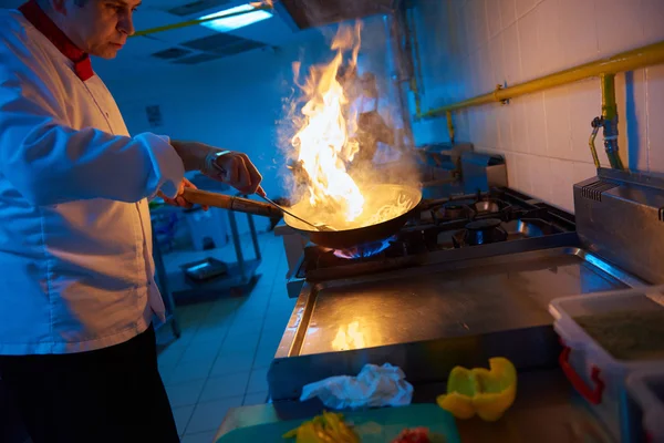 Kocken förbereder grönsaker med eld — Stockfoto