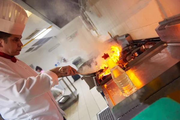 Chef-kok voorbereiden groenten met vuur — Stockfoto