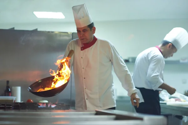 Kocken förbereder grönsaker med eld — Stockfoto