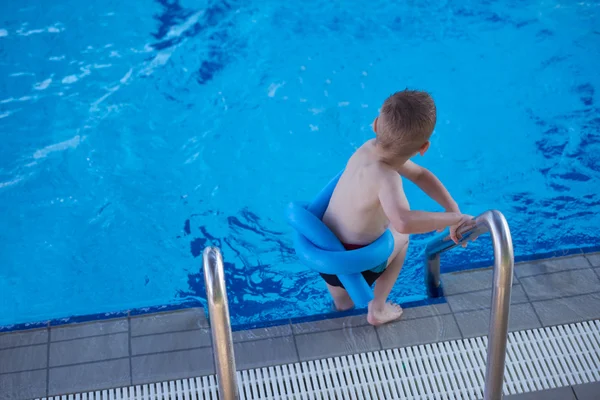 Мальчик на уроке плавания в бассейне — стоковое фото