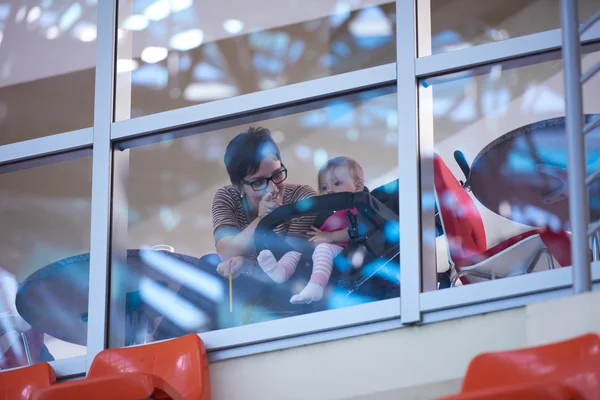 Baby und Mutter blicken durch Fenster — Stockfoto
