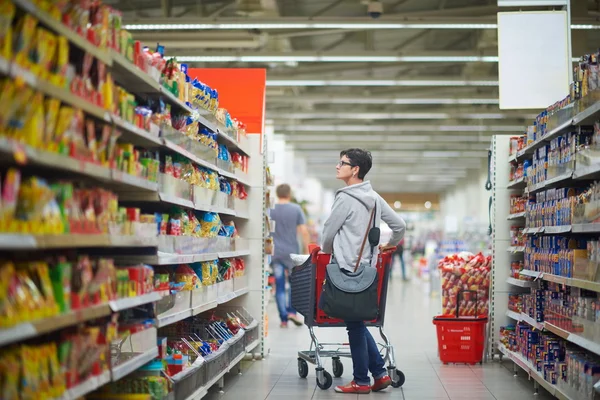 Žena v supermarketu úložišti — Stock fotografie