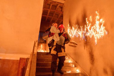 Kurtarılmış bir kadını acil durum tahliyesi sırasında yanan merdivenlerden aşağı taşıyan cesur itfaiyeci, kahramanlığı ve tehlikeli durumlarda hayat kurtarmayı sembolize ediyor.