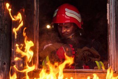 Bir itfaiyeci yanan bir binadan bir bebeği kurtarıyor. İtfaiyeci harekete geçti, çocuğu acil durumdan kurtardı. Bu görüntü cesaret ve kurtarma temalarını göstermek için kullanılabilir.