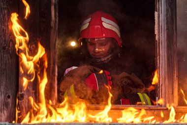 Bir itfaiyeci yanan bir binadan bir bebeği kurtarıyor. İtfaiyeci harekete geçti, çocuğu acil durumdan kurtardı. Bu görüntü cesaret ve kurtarma temalarını göstermek için kullanılabilir.