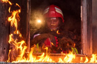 Bir itfaiyeci yanan bir binadan bir bebeği kurtarıyor. İtfaiyeci harekete geçti, çocuğu acil durumdan kurtardı. Bu görüntü cesaret ve kurtarma temalarını göstermek için kullanılabilir.