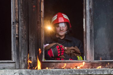Tam koruyucu donanımlı bir itfaiyeci yanan bir binadan bir bebeği kurtarırken görülüyor. Görüntü, acil durumlarda itfaiyecilerin cesaretini ve adanmışlığını gösteriyor.