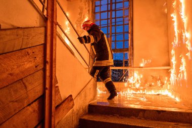 Bir itfaiyeci kurtarma operasyonu sırasında merdiveni cesurca yakar. Bu görüntü tehlike ve acil durumu yakalar, koruma ve mesleki eylemlerin altını çizer