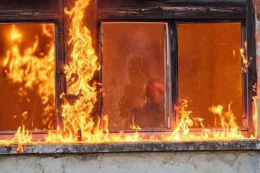Bir itfaiyeci yanan bir binadan bir bebeği kurtarıyor. İtfaiyeci harekete geçti, çocuğu acil durumdan kurtardı. Bu görüntü cesaret ve kurtarma temalarını göstermek için kullanılabilir.