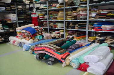 Kumaş rulo ve tekstil bir depoda raflarda. Tekstil endüstrisi, kumaş üretimi, kumaş, malzeme ve malzeme deposu bir kumaş mağazasında, tekstil fabrikasında. Sonraki resmin için bu resmi kullan