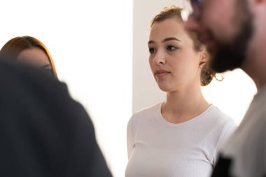 Genç bir kadının portresi dikkatle bir grup sağlığına ya da kapalı alandaki farkındalık seansına katılıyor. Konsantrasyon, farkındalık ve zihinsel berraklık kavramı