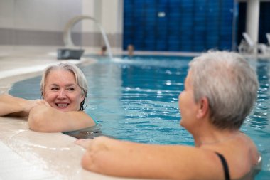 İki son sınıf öğrencisi, havuzda havuza yaslanmış, boş zamanlarının tadını çıkarıyorlar. Arkadaşlık, refah, aktif yaşam tarzı, rahatlama ve sağlıklı yaşlanma kavramı.