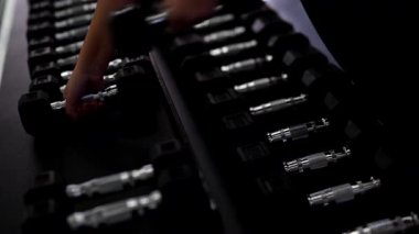 Spor salonunda birden fazla dambıl düzgünce düzenlenir. Bireysel olarak ağırlık seçer. Antrenman için ağırlık seçer ve kuvvet antrenmanına odaklanır..