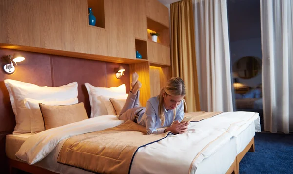 Junge Geschäftsfrau entspannt sich im Hotelzimmer — Stockfoto