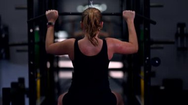 Spor salonunda egzersiz yapan bir insan otururken vücudunun üst kısmını kaldırır. Antrenman sırasında atmosfer enerji dolu, kendini adamış ve güç kazanma çabaları gösteriyor..