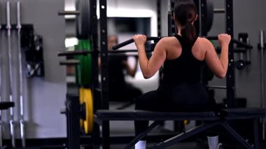 Spor salonunda egzersiz yapan bir insan otururken vücudunun üst kısmını kaldırır. Antrenman sırasında atmosfer enerji dolu, kendini adamış ve güç kazanma çabaları gösteriyor..