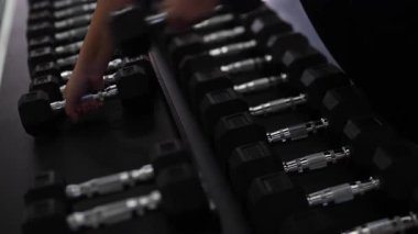 Spor salonunda birden fazla dambıl düzgünce düzenlenir. Bireysel olarak ağırlık seçer. Antrenman için ağırlık seçer ve kuvvet antrenmanına odaklanır..