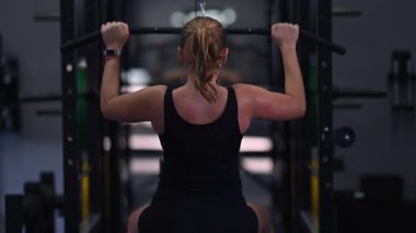 Spor salonunda egzersiz yapan bir insan otururken vücudunun üst kısmını kaldırır. Antrenman sırasında atmosfer enerji dolu, kendini adamış ve güç kazanma çabaları gösteriyor..