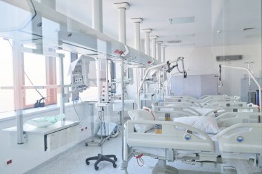 Geniş bir hastane odasında çok sayıda temiz çarşaf ve gelişmiş ekipman bulunur. Parlak güneş ışığı geniş pencerelerden geçerek iyileşme ortamını arttırır..
