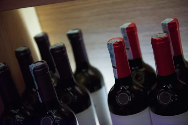 Wine bottles on a wooden shelf. — Stock Photo, Image