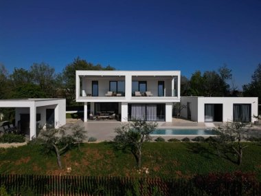 Havuzu, terasları ve insansız hava aracı tarafından yakalanan temiz minimalist mimarisi olan modern lüks villa. Parlak güneşli bir gün, çevreleyen yeşillikler, ve çağdaş açık yaşam alanları.