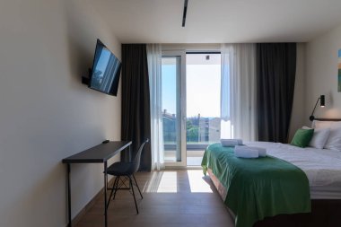 Lüks bir villada, özel bir yüzme havuzuna açılan büyük cam kapıları olan modern açık planlı oturma ve yemek odası, açık havada geniş ve zarif bir yaşam deneyimi sunuyor..