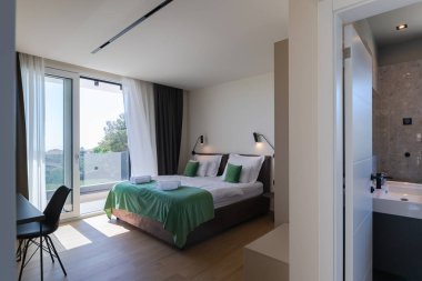 Lüks bir villada, özel bir yüzme havuzuna açılan büyük cam kapıları olan modern açık planlı oturma ve yemek odası, açık havada geniş ve zarif bir yaşam deneyimi sunuyor..