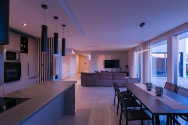 Rahat bir kanepe ve büyüleyici bir özel yüzme havuzu ve yemyeşil bahçeye açılan panoramik cam kapıları olan modern, parlak bir oturma odası. Lüks ve açık havada yaşamak için mükemmel.