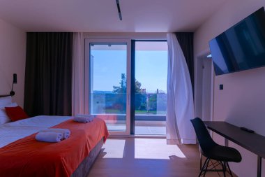 Lüks bir villada, özel bir yüzme havuzuna açılan büyük cam kapıları olan modern açık planlı oturma ve yemek odası, açık havada geniş ve zarif bir yaşam deneyimi sunuyor..