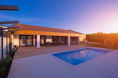 Büyüleyici bir yüzme havuzu ve geniş ahşap güvertesi olan modern bir villa. Açık havada yemek için mükemmel. Güzel bir gün batımı ve berrak gökyüzü ile altın saati yakalıyor, lüks içinde yaşıyor ve huzurlu