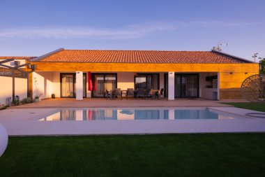 Özel bir yüzme havuzu ve geniş ahşap güvertesi olan modern villa, fayanslı çatı altında bir açık hava yemek alanı barındırıyor. Güzel, güneşli bir ortamda lüks bir yaşam ve rahatlığın tadını çıkar..