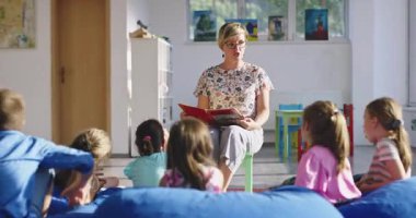 El hijyenini gösteren koruyucu bir maske takan kadın öğretmen ya da salgın ya da grip sezonunda sınıfta maske takan öğrencilere bir ders anlatıyor. Sinematik ağır çekim