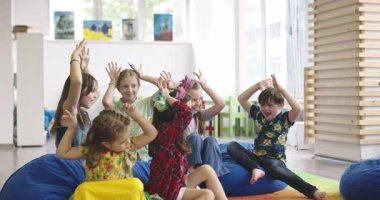 Öğretmenleri takip eden bir grup çocuk, eğitimsel içerik ve çocuk gelişimi temaları için mükemmel, neşeli bir ortamda etkileşimli bir sınıf aktivitesi içinde..