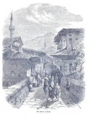 Türkiye 'nin Bursa kentindeki taştan köprü boyunca uzanan caddede geleneksel binalar, minareler ve kalabalıklar, tarihi bir cazibe ve eski bir kasaba ortamında günlük hayatı yakalıyorlar..